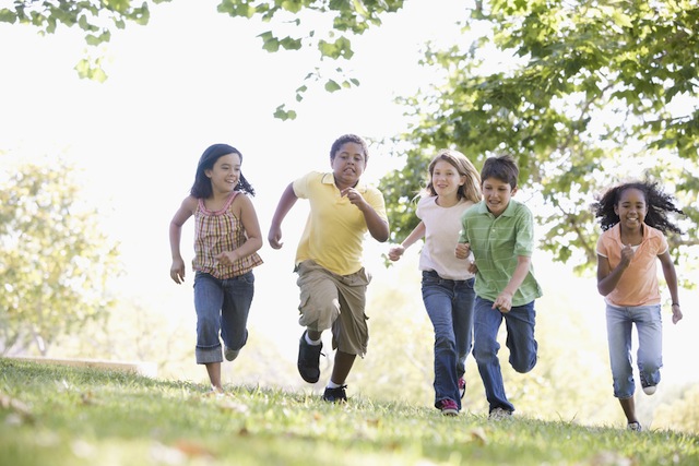 Five young friends running outdoors smiling